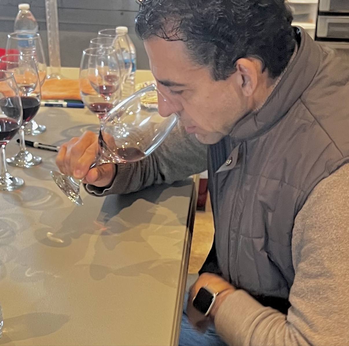 Close portrait of Guillermo Seta evaluating wine in the blending room