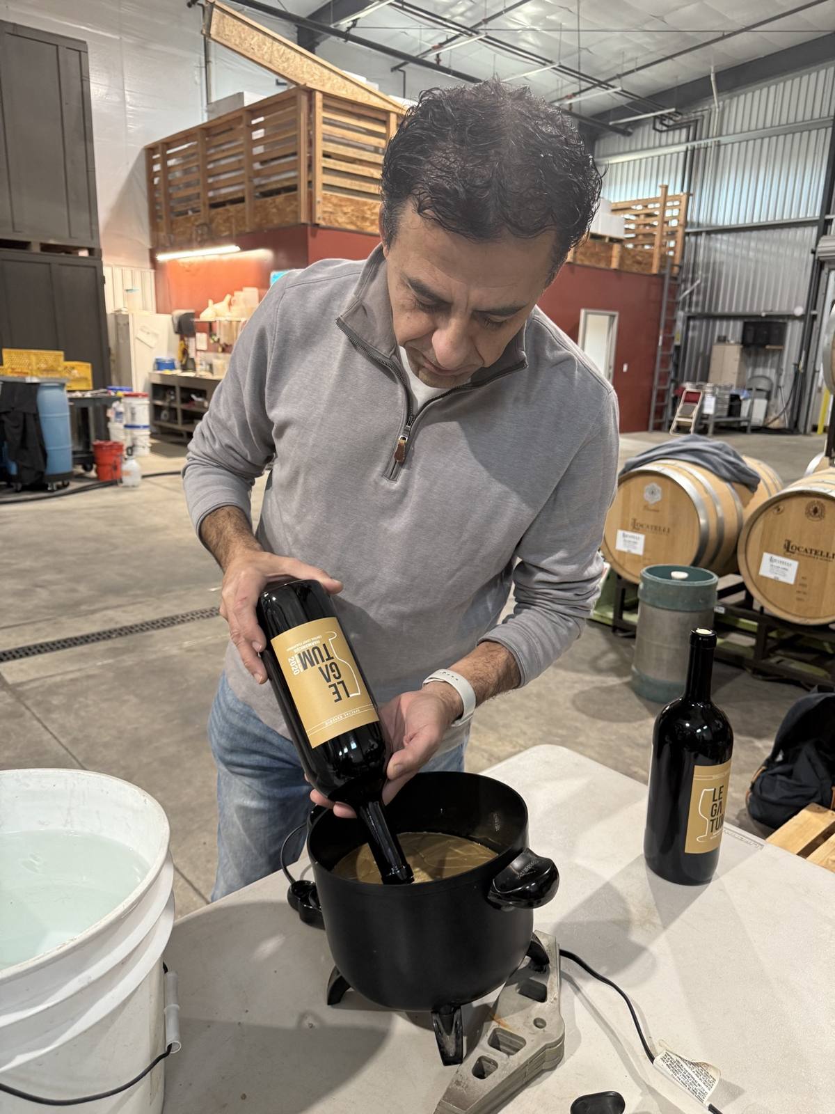 Guillermo Seta dipping the neck of a Legatum bottle into molten gold wax at the winery