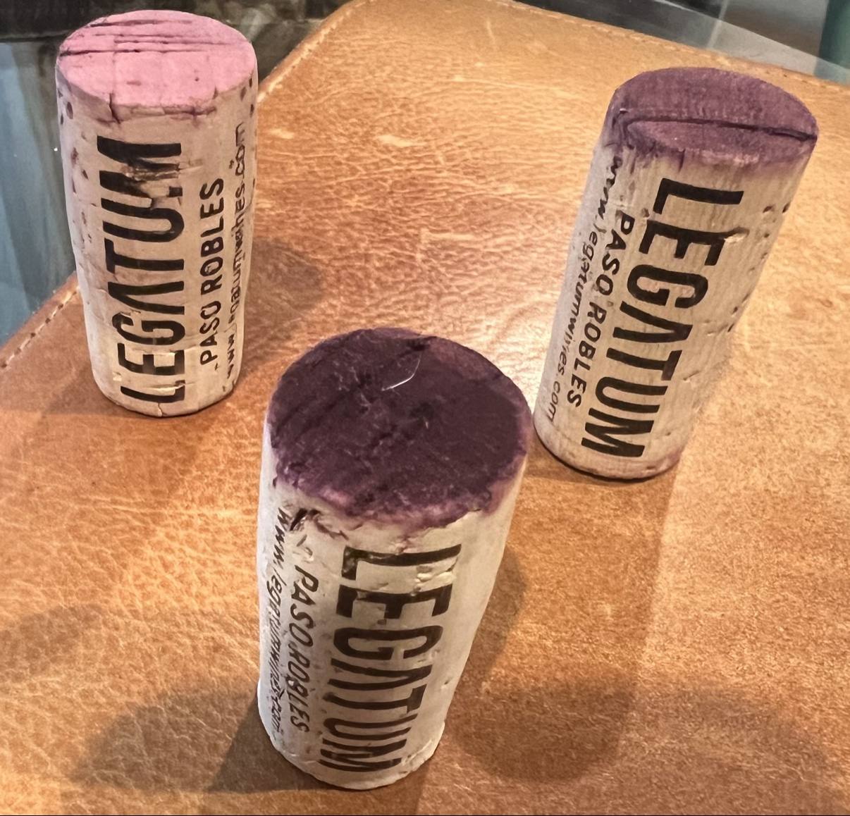 Wine-stained Legatum Paso Robles corks resting on leather