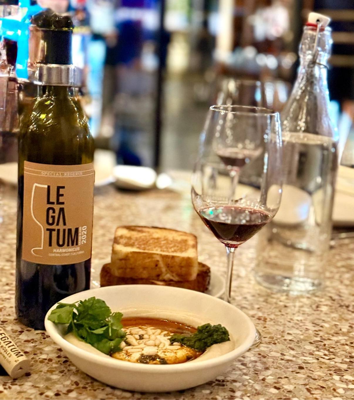 Legatum 2020 Harmonicus Special Reserve beside a composed dish and glass of wine