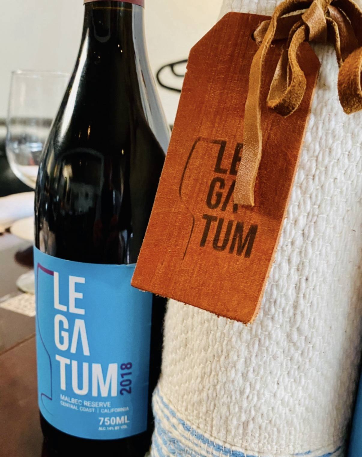Legatum 2018 Malbec Reserve beside a woven sleeve and leather tag