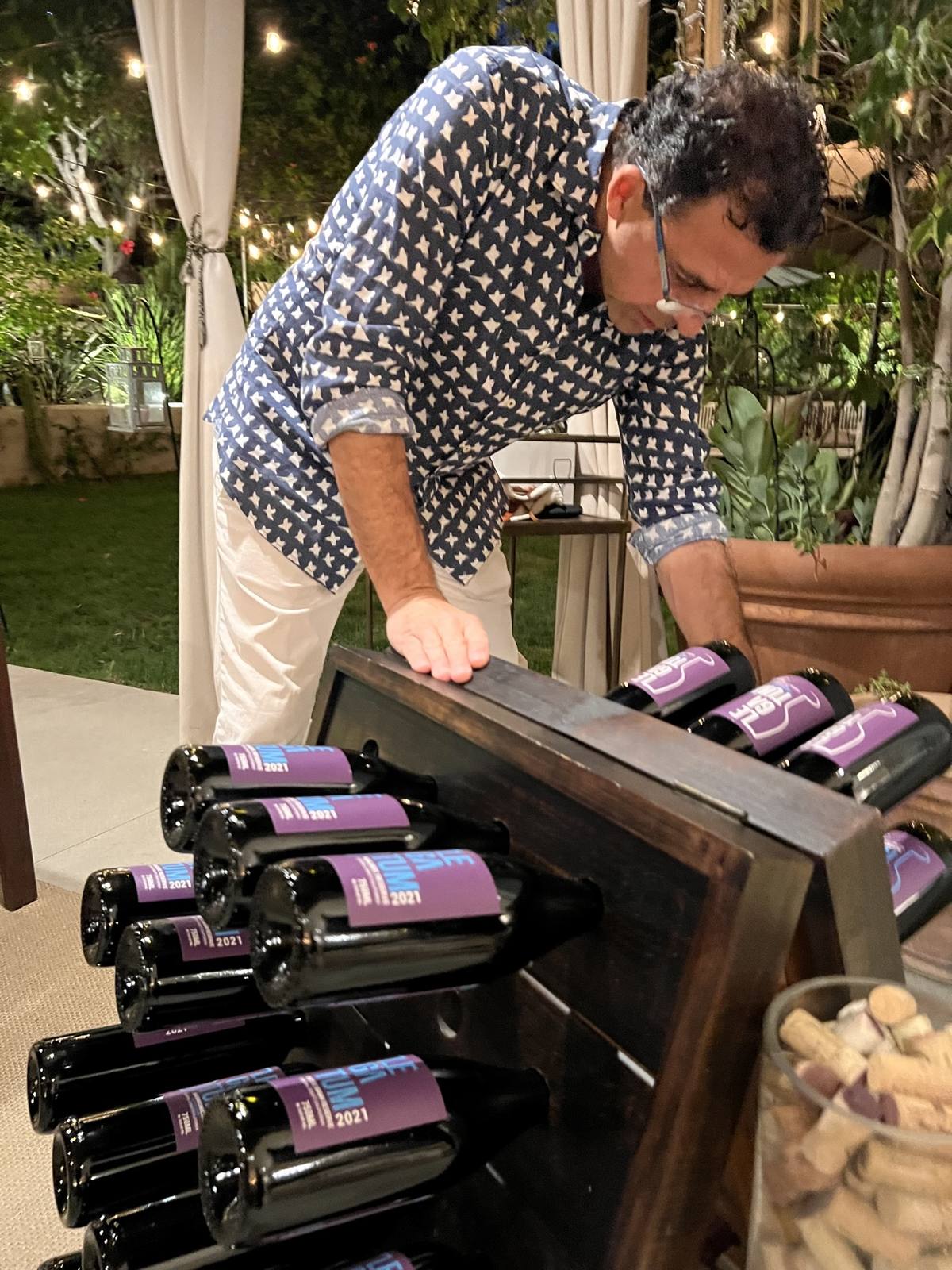 Guillermo Seta arranging purple-label 2021 Legatum bottles for guests