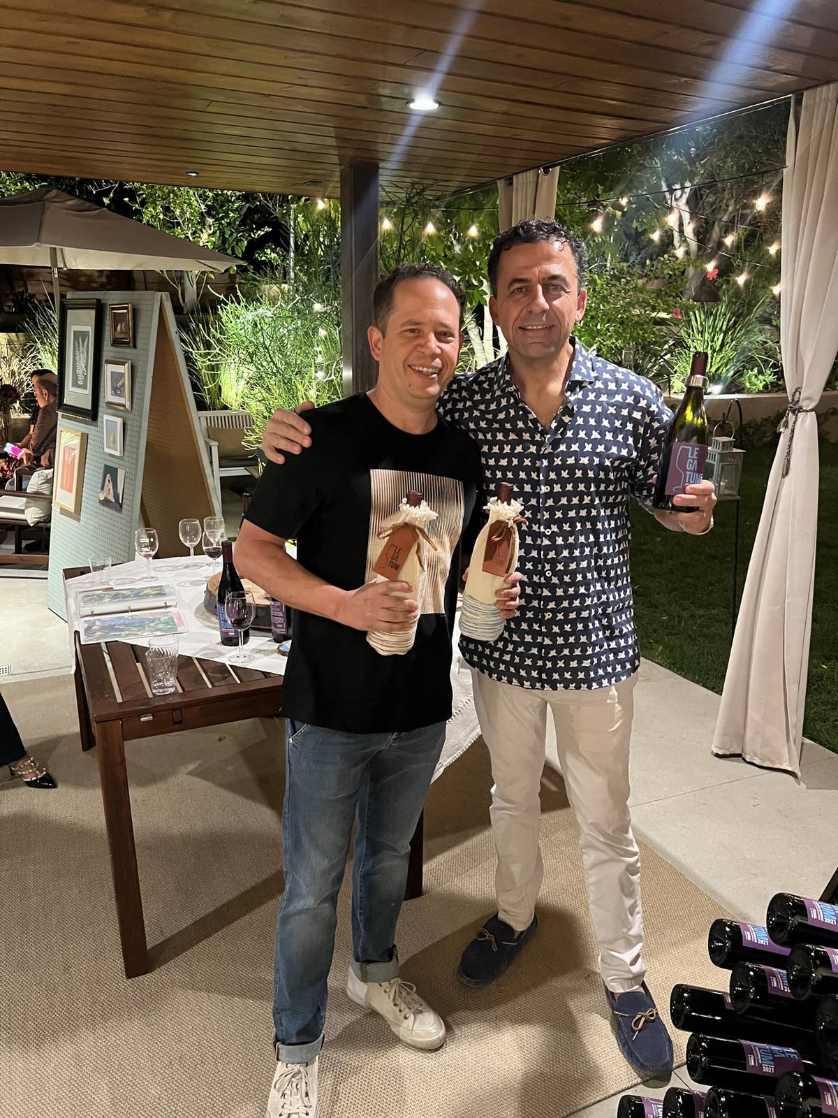 Guillermo Seta holding a Legatum bottle during an evening gathering