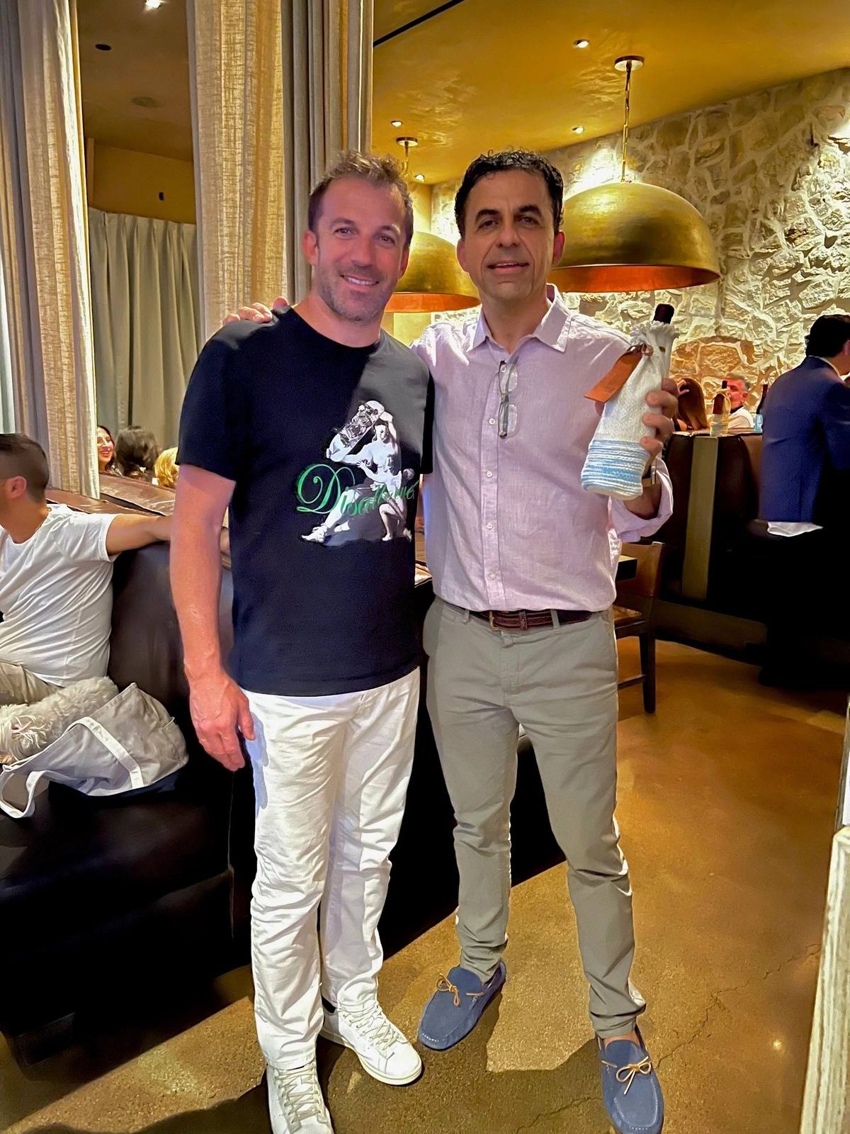 Alessandro Del Piero with his arm around Guillermo Seta, who holds a Legatum bottle in its white-and-blue woven sleeve inside N10 restaurant