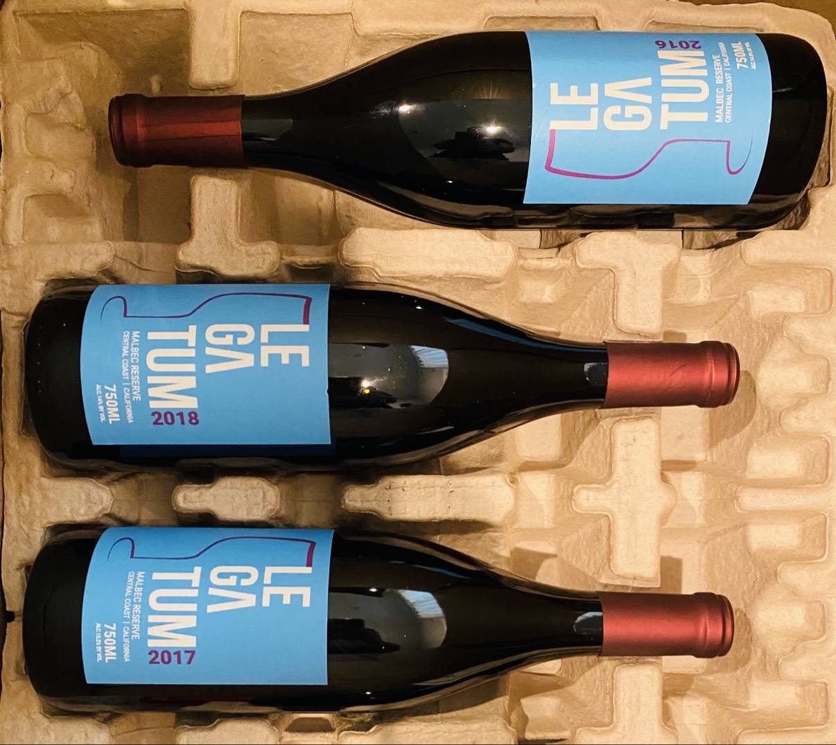 Blue-label 2016, 2017, and 2018 Legatum Malbec Reserves arranged as a vertical