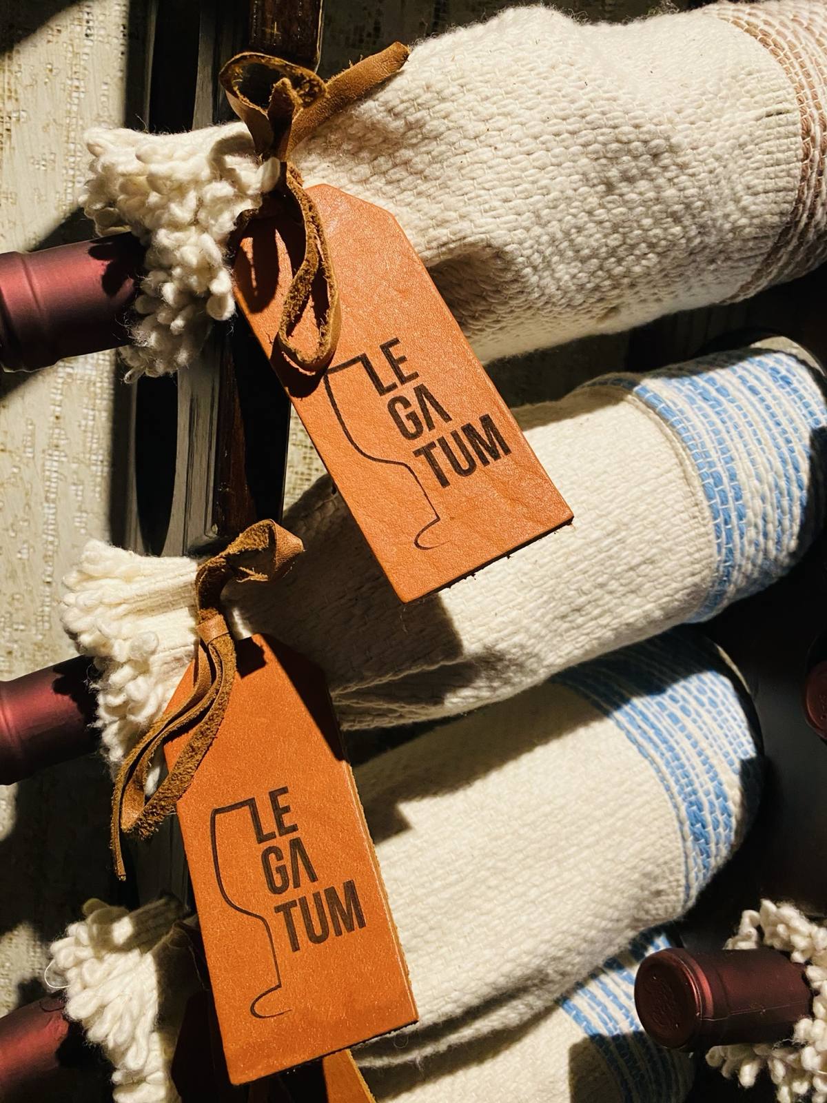 Legatum woven sleeves and brown leather tags displayed at Bodega Malbec